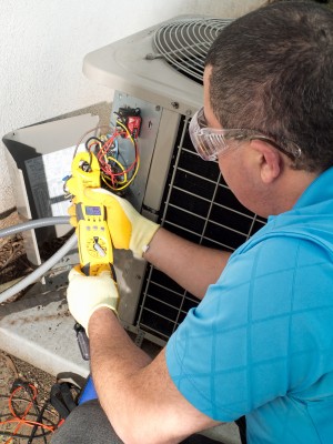 Boulder air conditioner repair man checks resistance with an ohmmeter